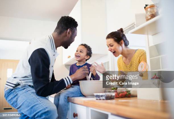 Parents and toddler son baking in kitchen