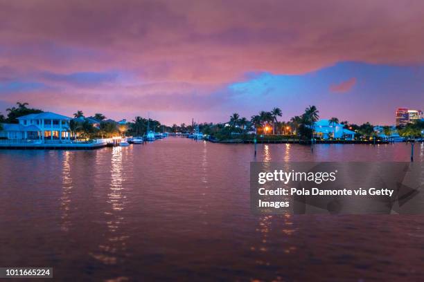 front view of the sun coming down at sunset in fort lauderdale canals. luxury yachts in las olas boulevard, florida, usa - waterfront house stock pictures, royalty-free photos & images