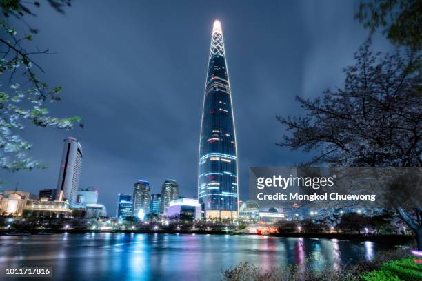 cityscape of seoul downtown city skyline with cherry blossom at night, aerial view of skyscraper at seokchon lake at nightand sakura around lake. the amazing modern building at seoul city, south korea - south corea foto e immagini stock