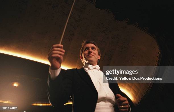 orchestra conductor - conductor leading orchestra stock-fotos und bilder