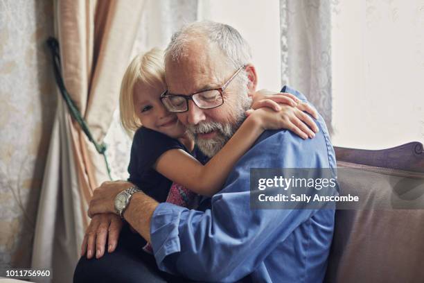 little girl giving her grandfather a hug - affectionate stock pictures, royalty-free photos & images