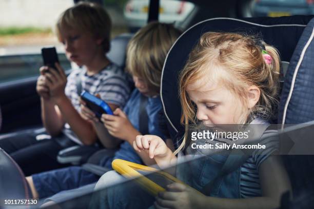 children using electronic devices - girl in car with ipad stock pictures, royalty-free photos & images