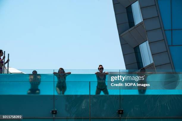 Several tourists are seen enjoying a swim in the pool of a hotel as they try and cool off. Barcelona has been hit by a heatwave, Strolling through...