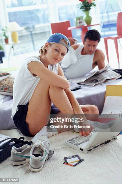 woman and computer with man in background - datenspeicher diskette stock-fotos und bilder
