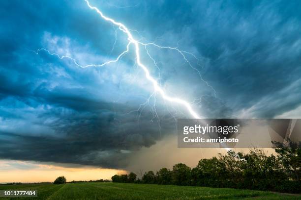 cielo nuvoloso tempesta con fulmine sul paesaggio rurale - tempo atmosferico foto e immagini stock