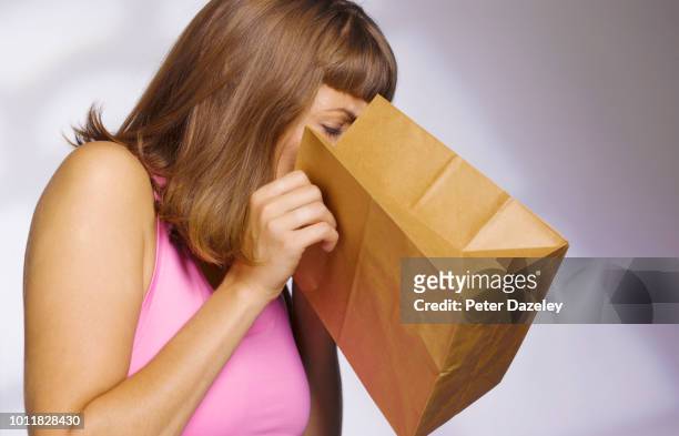 woman vomiting into paperbag - vômito - fotografias e filmes do acervo