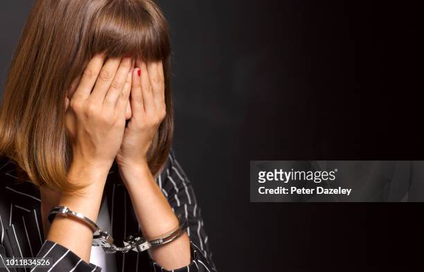 arrested woman woman feeling guilty - schuldspruch stock-fotos und bilder