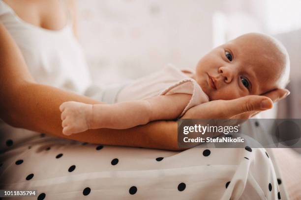 moeder haar baby te houden - pasgeborene stockfoto's en -beelden