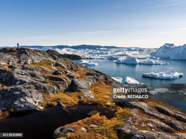 Tourists admiring the fjord Ilulissat Icefjord also called kangia or Ilulissat Kangerlua The icefjord is listed as UNESCO world heritage America...