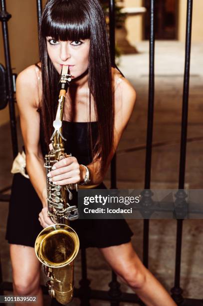 young brunette girl playing sax outdoor - saxophonist stock pictures, royalty-free photos & images