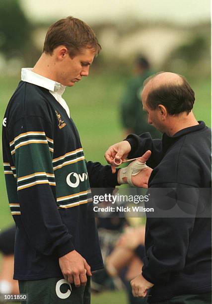 Steven Larkham of Australia gets his broken thumb taped during a training session at the Portmarnock Sport Centre, Dublin, Ireland. Larkham is making...