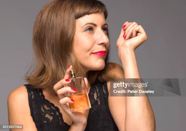 woman smelling newly applied perfume - perfume stock pictures, royalty-free photos & images