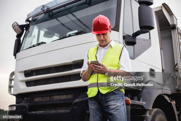 conductor de camión mediante una aplicación móvil - conductor oficio fotografías e imágenes de stock