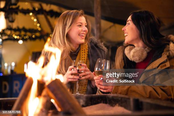 two friends laughing together - fire pit stock pictures, royalty-free photos & images