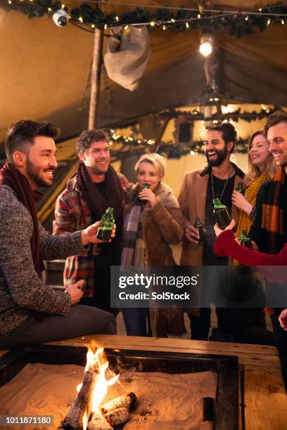 enjoying christmas drinks with some friends - beer fire stock pictures, royalty-free photos & images