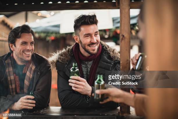 group of men catch up over a beer - only mid adult men stock pictures, royalty-free photos & images