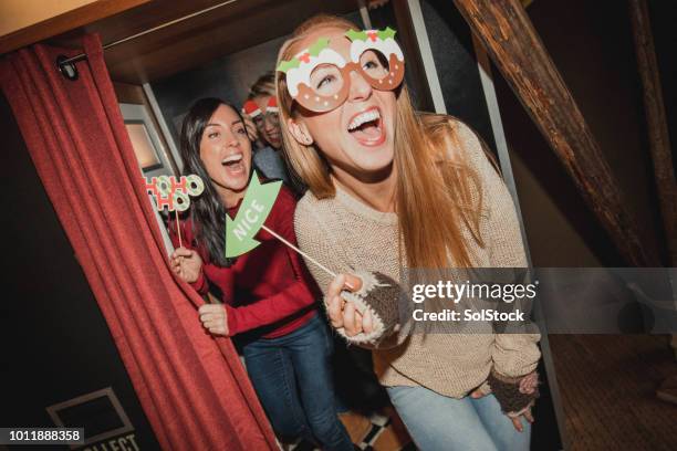 three friends having fun in a photo booth - photobooth stock pictures, royalty-free photos & images