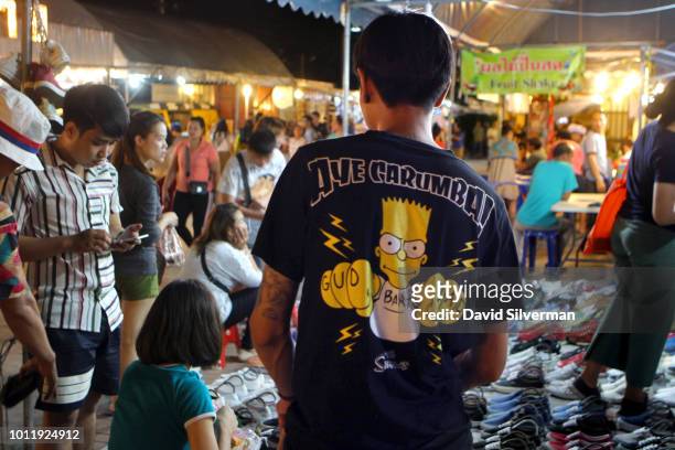 Thai vendor wears a Bart Simpson t-shirt at the Rot Fai Market, Srinakarin on July 27, 2018 in Bangkok, Thailand. Rot Fai Market is an open-air...