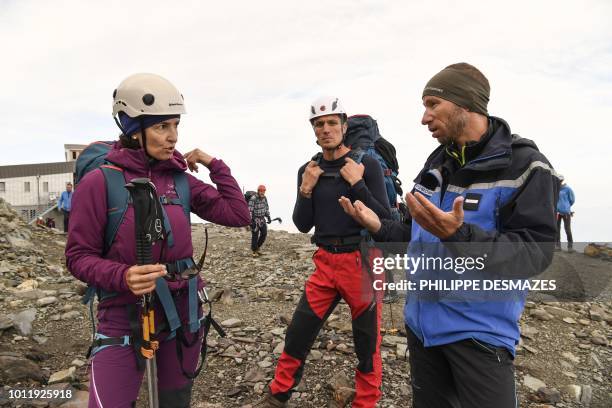 French gendarme talks with a group of mountaineers on August 6, 2018 near Saint-Gervais, below the 'Couloir du Gouter' on the 'Voie Royale' route to...