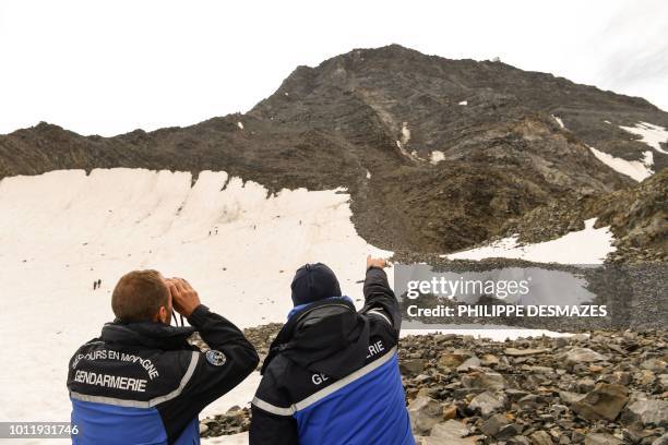 French gendarmes watch mountaineers taking the 'Couloir du Gouter' on the 'Voie Royale" route to climb atop the Mont-Blanc peak on August 6, 2018 in...