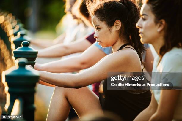 young woman stretching with fitness group - german indian society stock pictures, royalty-free photos & images