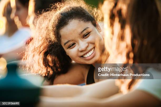 young woman smiling while out with fitness group - fitness vitality wellbeing photos et images de collection