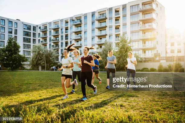 women's fitness group jogging in city - germany womens training stockfoto's en -beelden