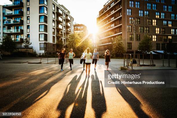fitness instructor talking to class outdoors - urban running foto e immagini stock