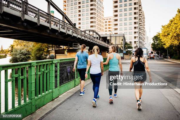 fitness group cooling down after city run - wandelen lichaamsbeweging stockfoto's en -beelden