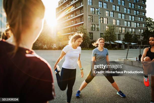 group of women keeping fit together outdoors - german indian society stock pictures, royalty-free photos & images