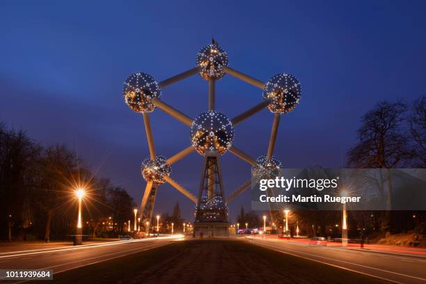 the exterior of atomium illuminated at dusk twilight in parc des expositions in brussels. brussels, belgium, europe. - atomium monument stock pictures, royalty-free photos & images