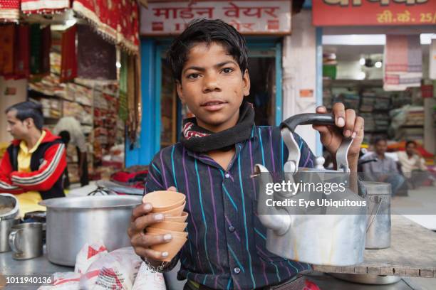 India, Uttar Pradesh, Varanasi, A chai boy serving tea.