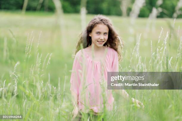 mädchen geht durch eine wiese mit hohem gras - mädchen wiese stockfoto's en -beelden