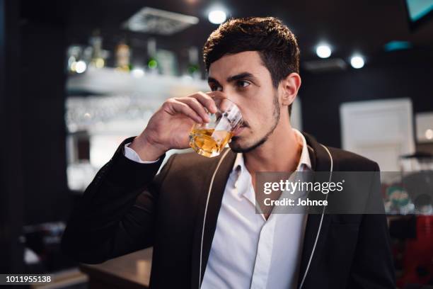 homem elegante, bebendo whisky no bar - scotch whiskey - fotografias e filmes do acervo