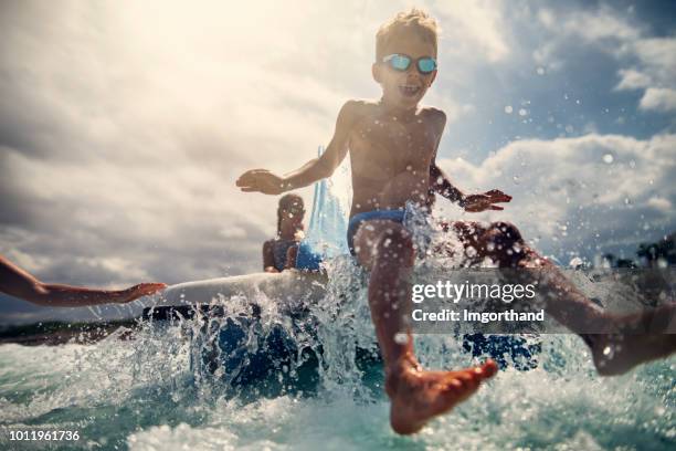 kids enjoying pedal boat and sliding to the sea - pedal boat stock pictures, royalty-free photos & images