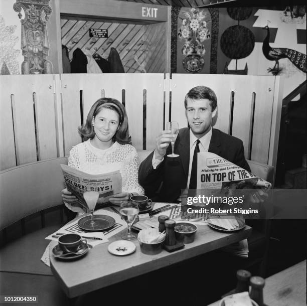 English soccer player Geoff Hurst with his wife Judith at a cafe while reading newspaper celebrating England's victory at the 1966 FIFA World Cup...