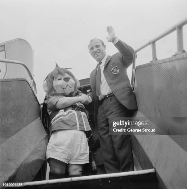 German soccer player Uwe Seeler of West Germany with a lion mascot, embarking a flight to fly home after the 1966 Fifa World Cup, UK, 1st August 1966.