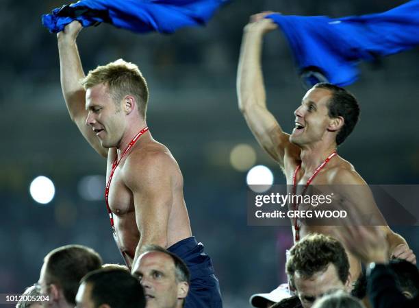 Participants wave their teeshirts as they march onto the field during the opening ceremony of the VI Gay Games in Sydney, 02 November 2002. The Gay...