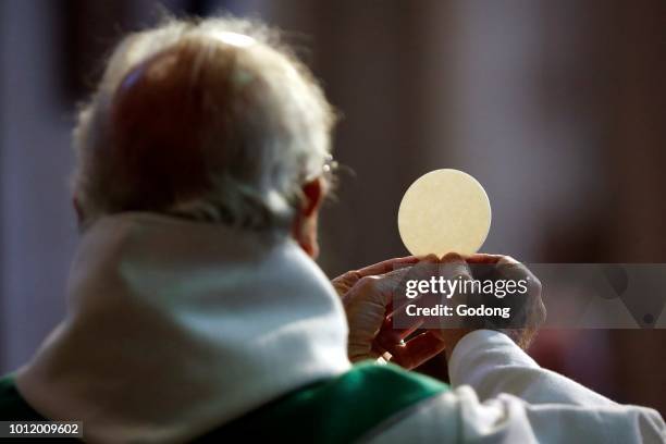 Saint-Jacques church. Catholic mass. Priest giving Holy Communion. Eucharist celebration. Sallanches. France.