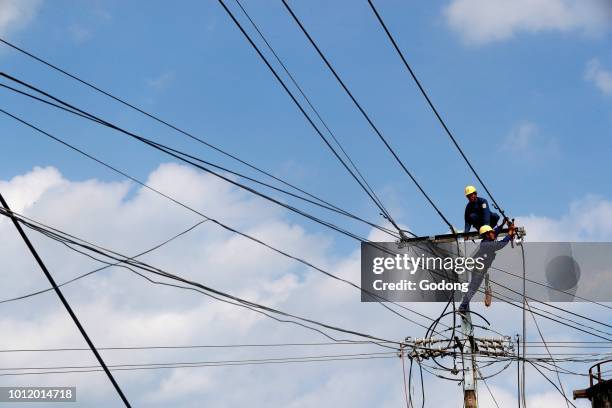 Maintenance electrician repairing electricity pylon. Cai Be. Vietnam.