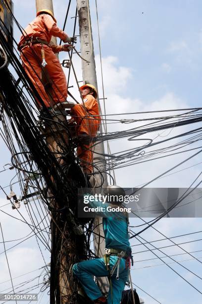 Maintenance electrician repairing electricity pylon. Cai Be. Vietnam.