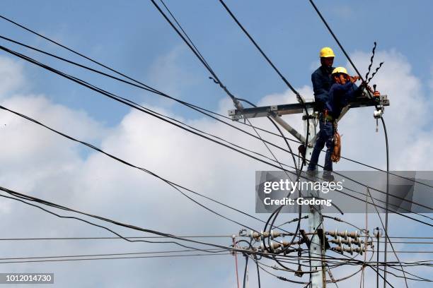 Maintenance electrician repairing electricity pylon. Cai Be. Vietnam.