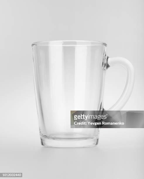 empty clear glass mug with reflections, isolated on white background - mug photos et images de collection