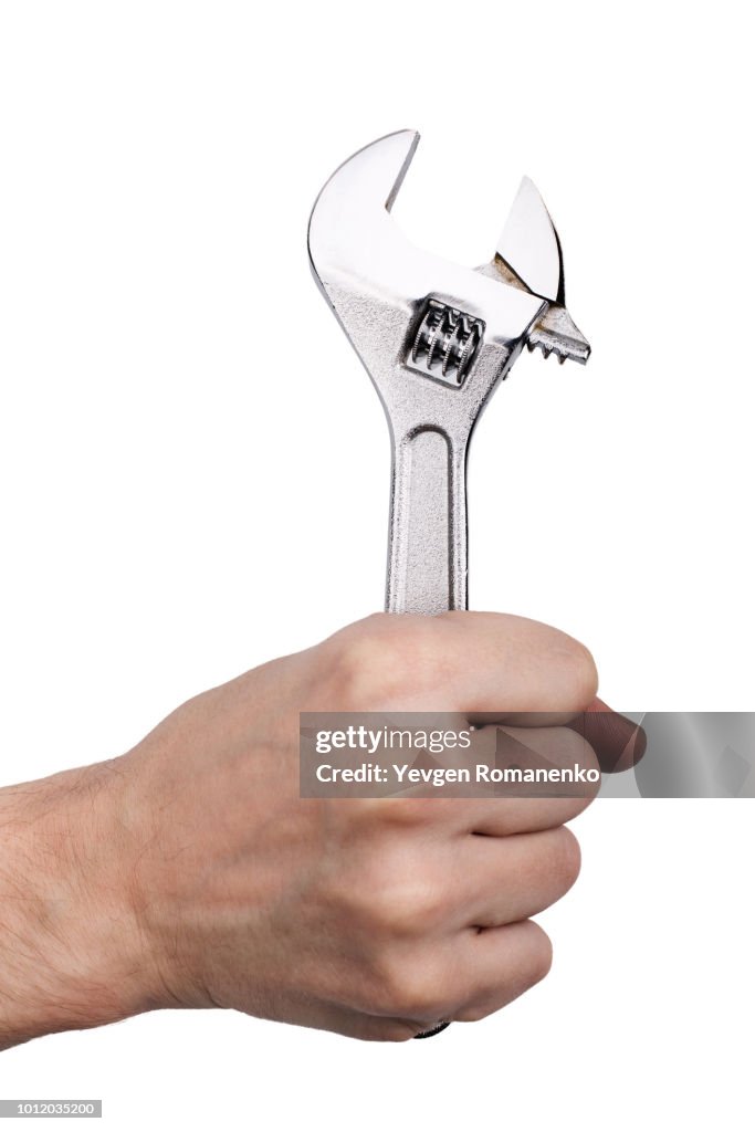 Hand holding adjustable wrench, isolated on white background