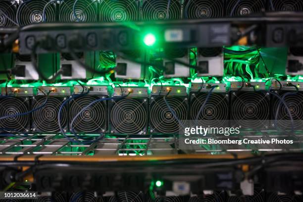 cryptocurrency mining rigs sit on racks at a facility - bitcoin mining stock pictures, royalty-free photos & images