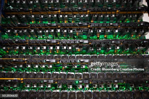 cryptocurrency mining rigs sit on racks at a facility - マイニング ストックフォトと画像