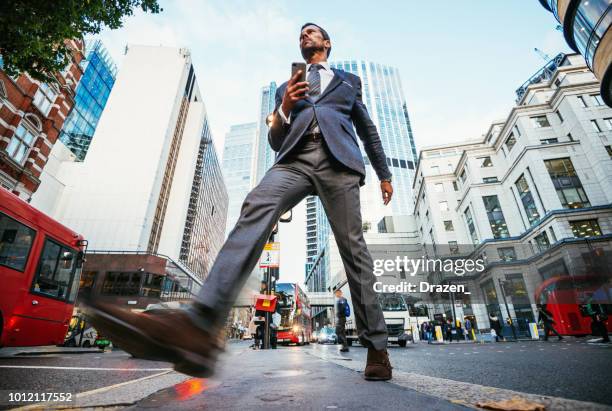 empresario en inglaterra cruzando la calle en la tarde - gran angular fotografías e imágenes de stock