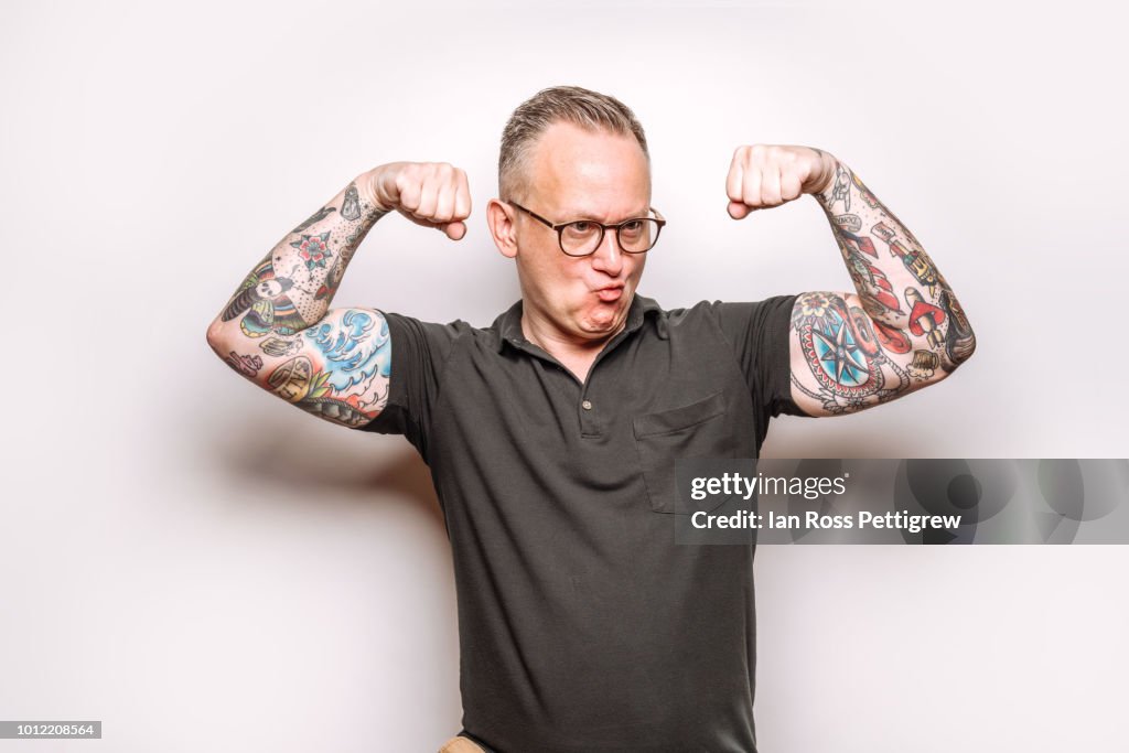 Middleaged Man With Tattoos Making Muscle Pose High-Res Stock Photo ...