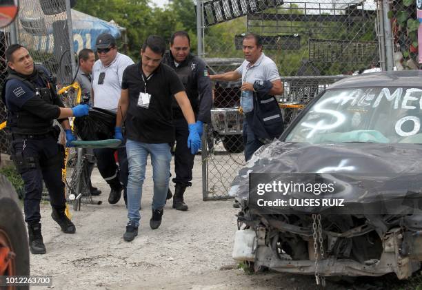 Forensic personnel carry the body of a man who died during a police chase after stealing a car and trying to flee in a municipal vehicle, in...