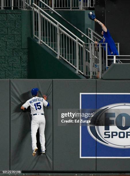 Fan catches a home run ball hit Javier Baez of the Chicago Cubs as Whit Merrifield of the Kansas City Royals looks on in the sixth inning at Kauffman...